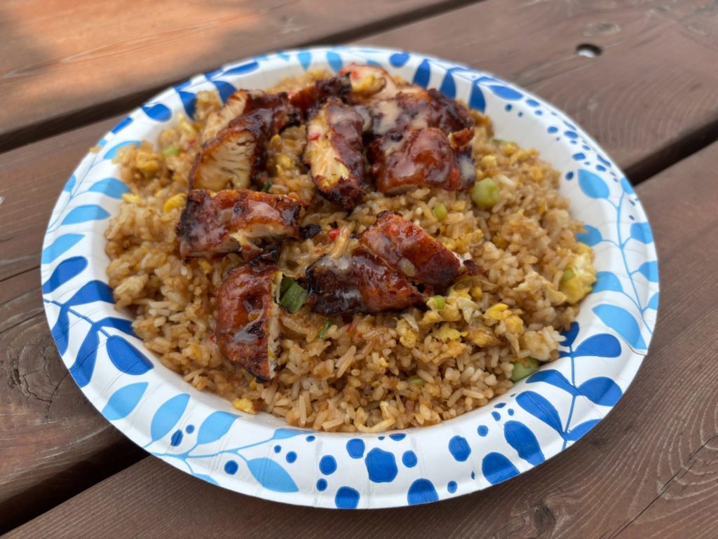 Sliced glazed chicken over fried rice