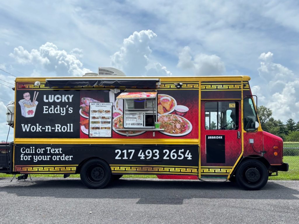 Side view of the Lucky Eddy's Wok-n-Roll food truck with its black and gold wrap